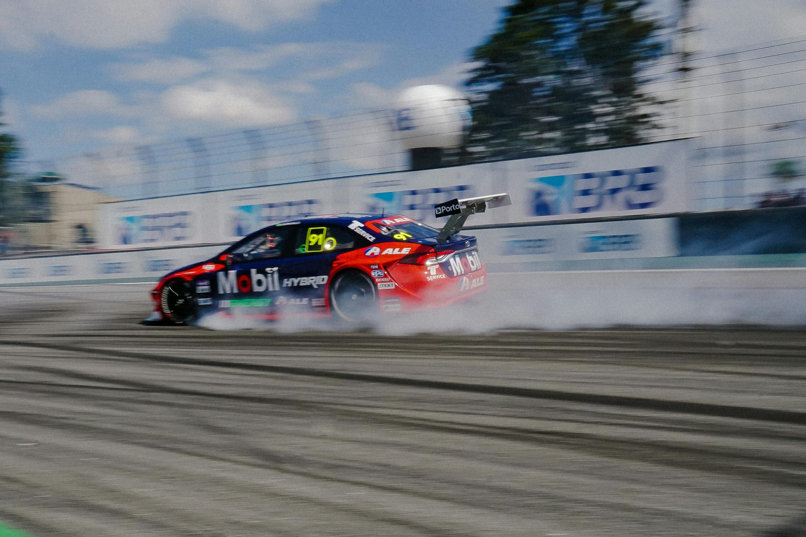 Exciting car racing action showcasing speed and motion on a sunny day track.