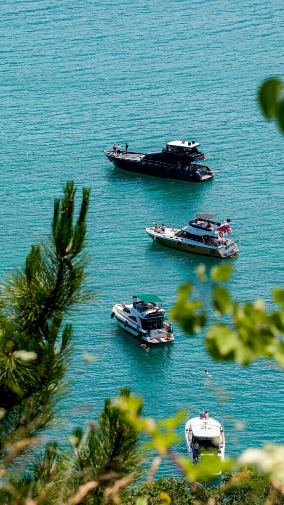 A picturesque scene of several boats anchored in the calm blue waters of Istanbul, Türkiye.