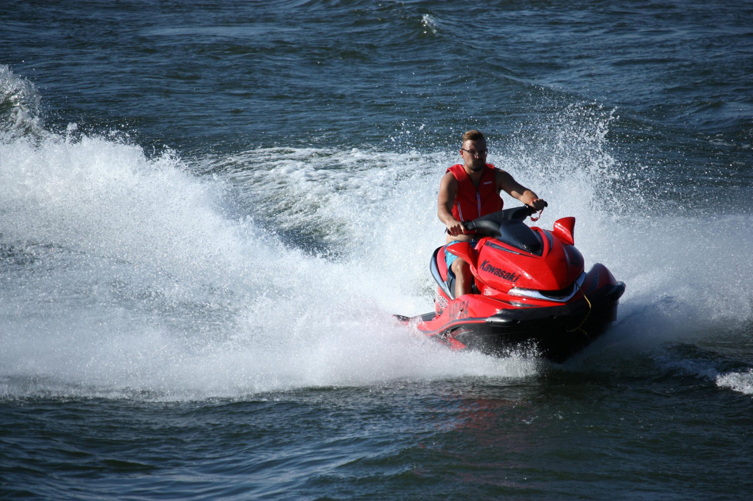 Dynamic capture of a man enjoying a high-speed jetski ride on open water.