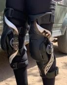 A-photograph-showing-a-motocross-rider-walking-with-premium-knee-braces-for-off-road-motorcyclists-which-protect-against-the-hyper-extending-of-the-knees-as-well-as-torsion-injuries