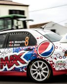Dynamic shot of a colorful race car speeding through Açores, Portugal, capturing the thrill of motorsports.
